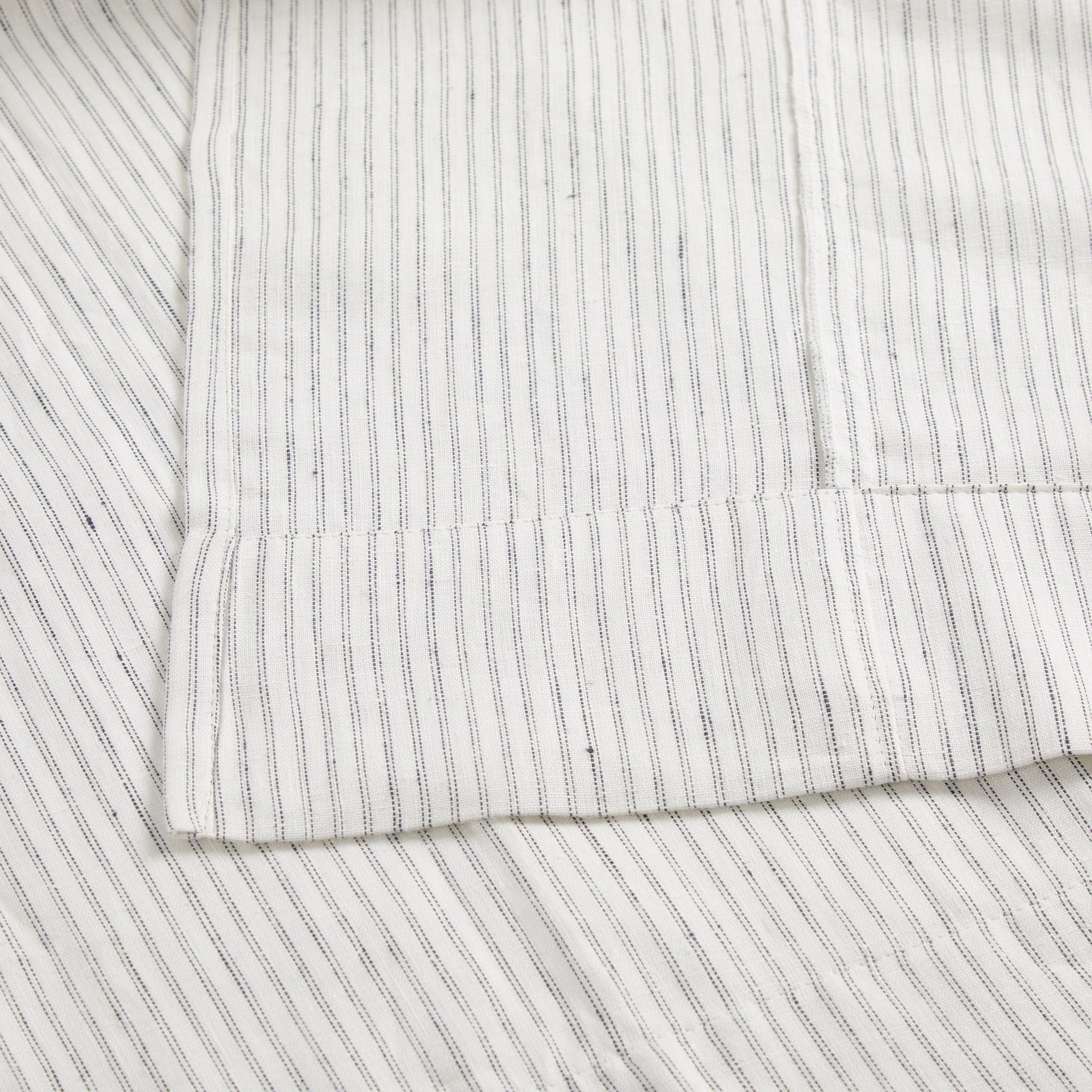 Close up of Tonic Living Verona Stripe Linen Shower Curtain showing tailored 4 inch bottom hem in black and white stripe.