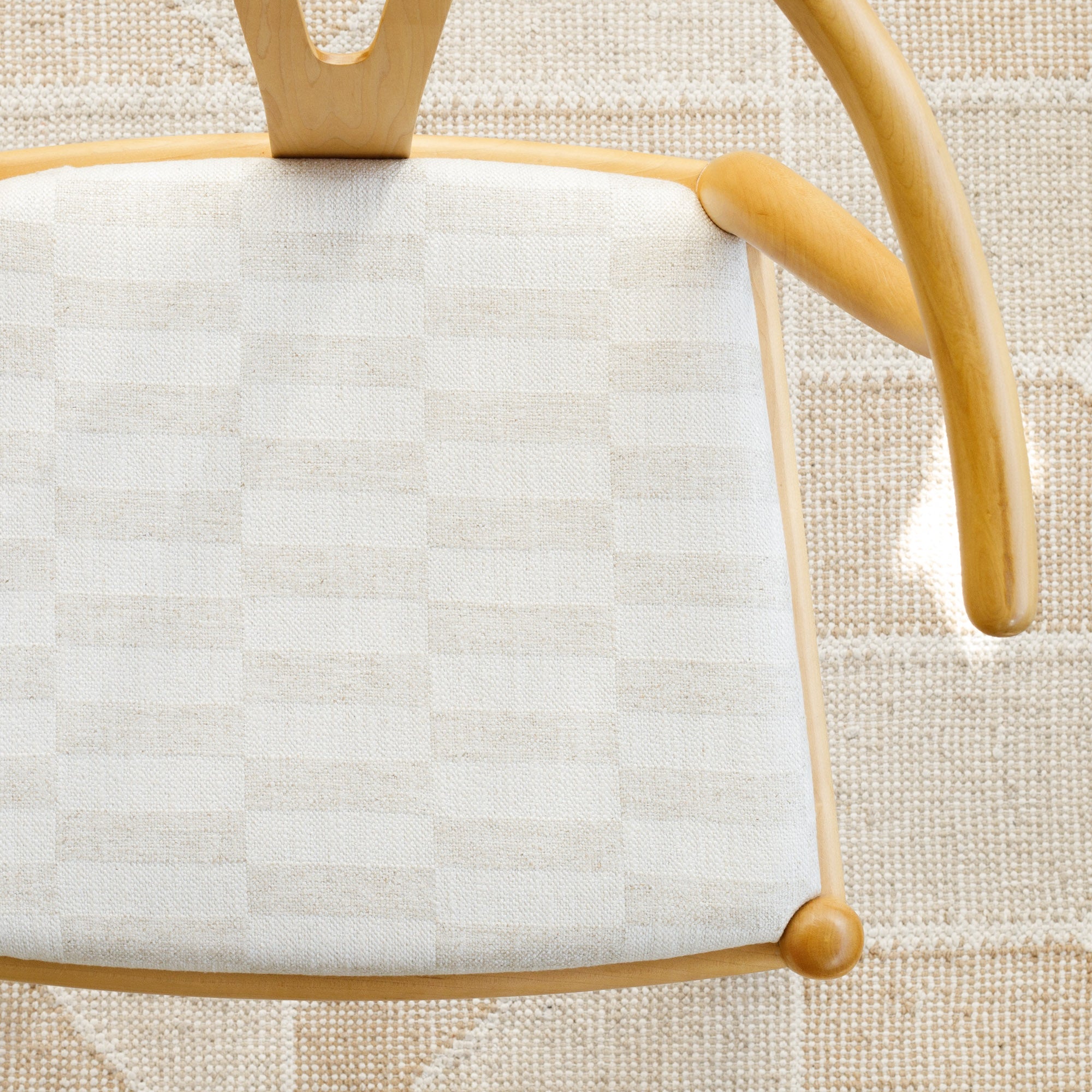 a cream and beige checkerboard patterned upholstered chair seat