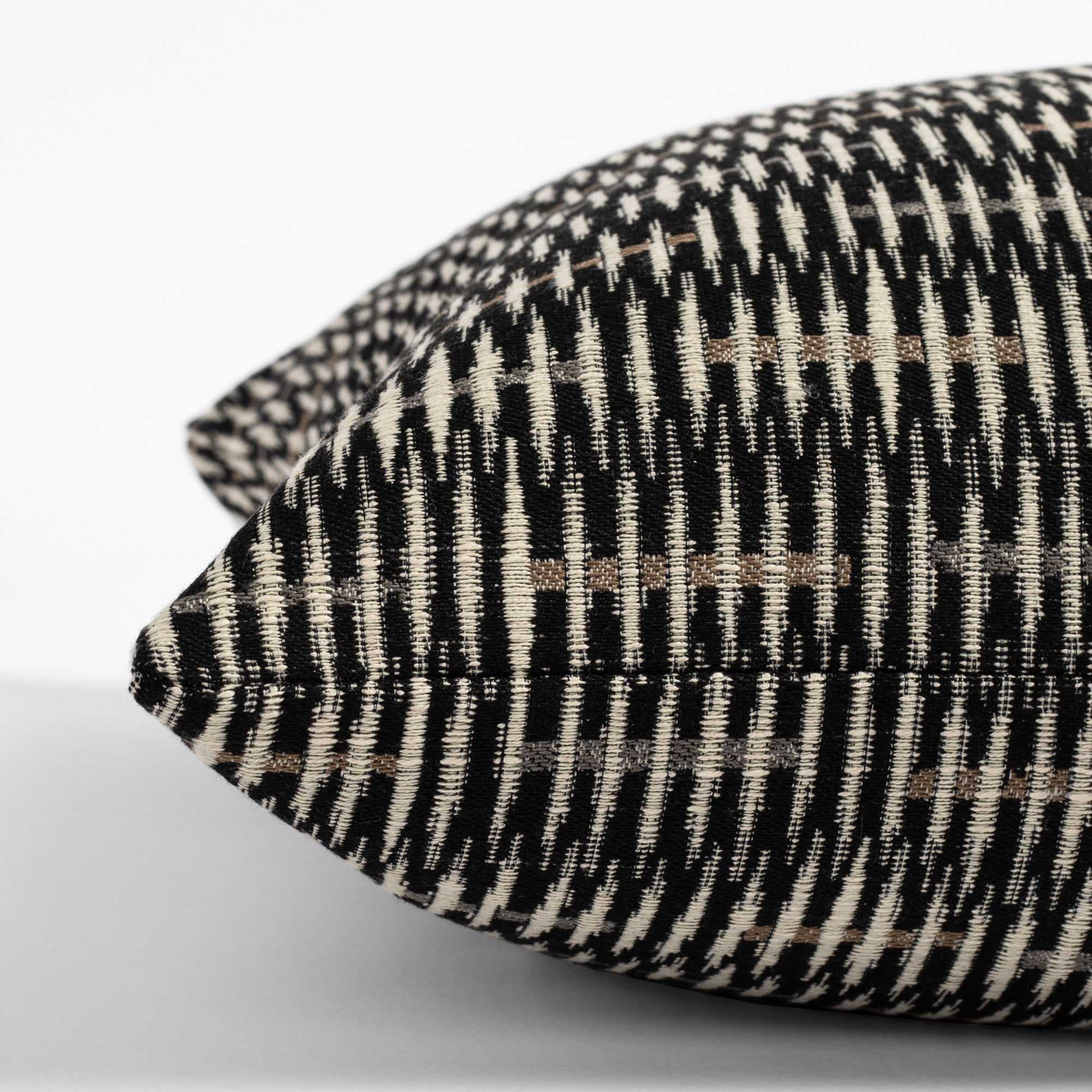 a black, brown and tan graphic throw pillow : side view