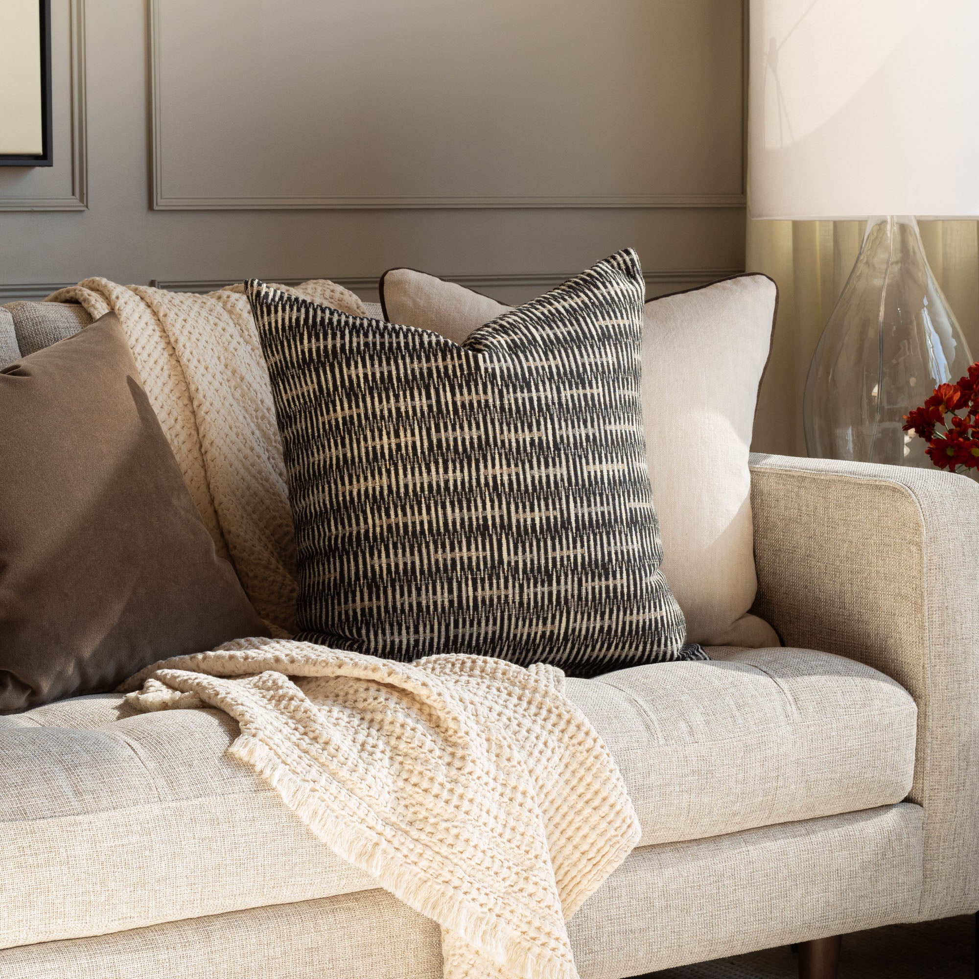 Bilbao Carbon, a black, brown and tan modern abstract patterned throw pillow paired with brown velvet truffle and tanner truffle for a living room scene by Tonic Living