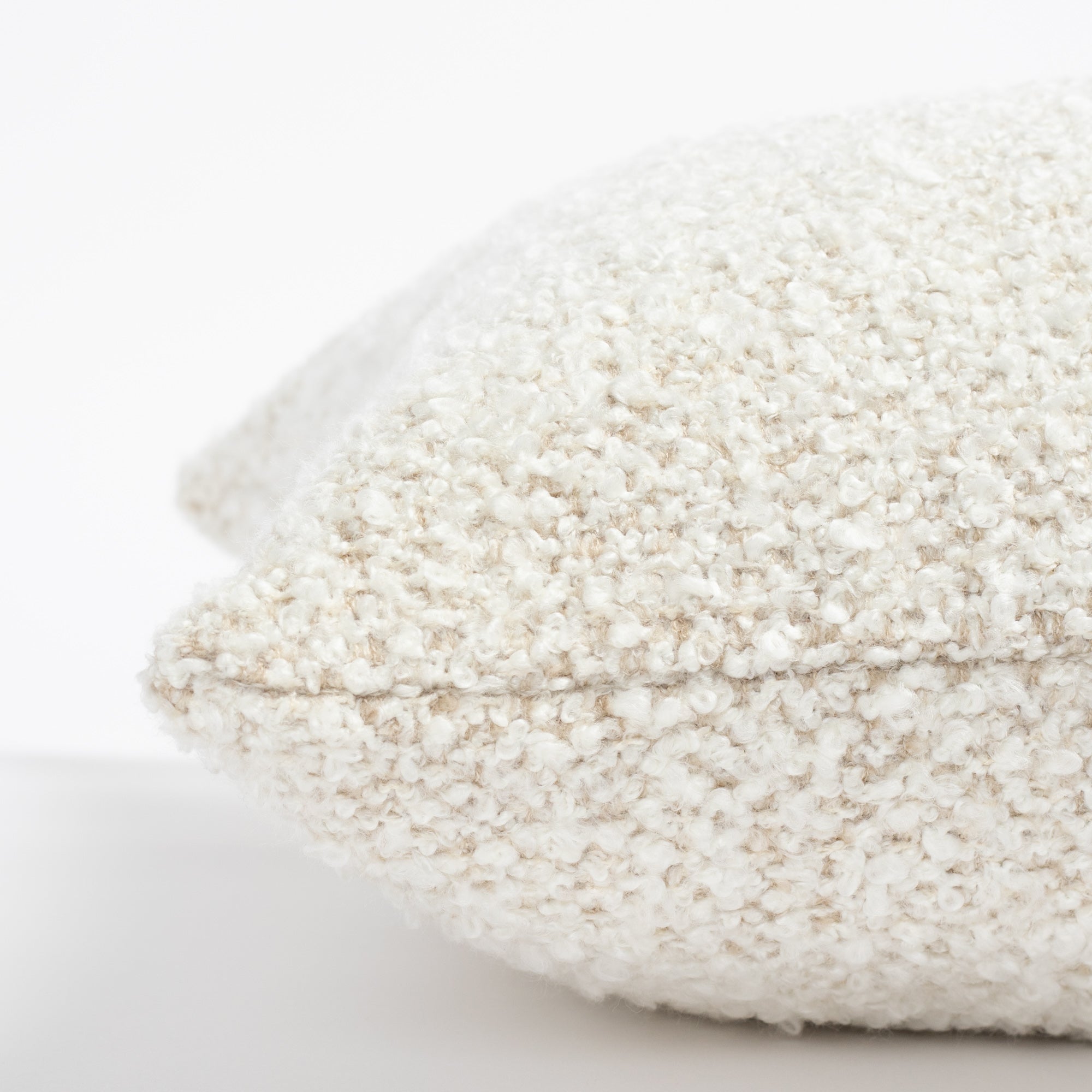 a cream boucle throw pillow: 22x22 pillow side view