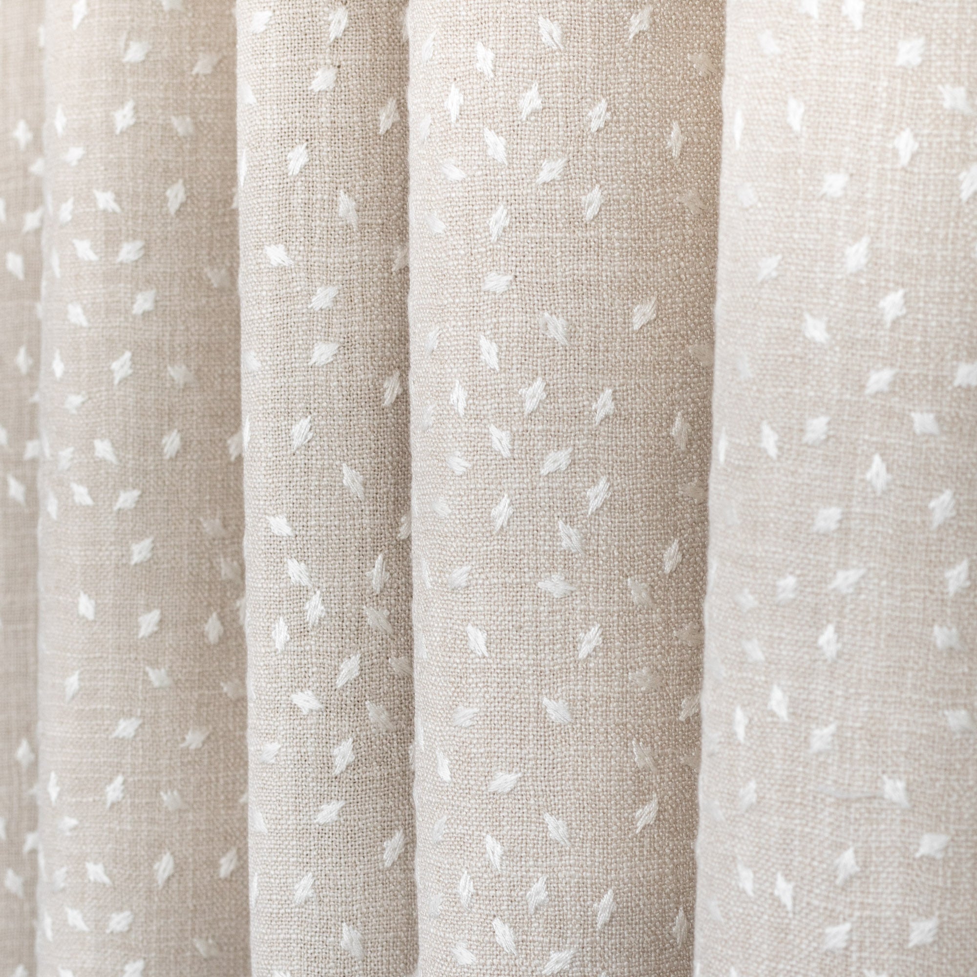 Masie Pearl, a sandy beige home decor fabric with a scattering of embroidered ivory flecks from Tonic Living