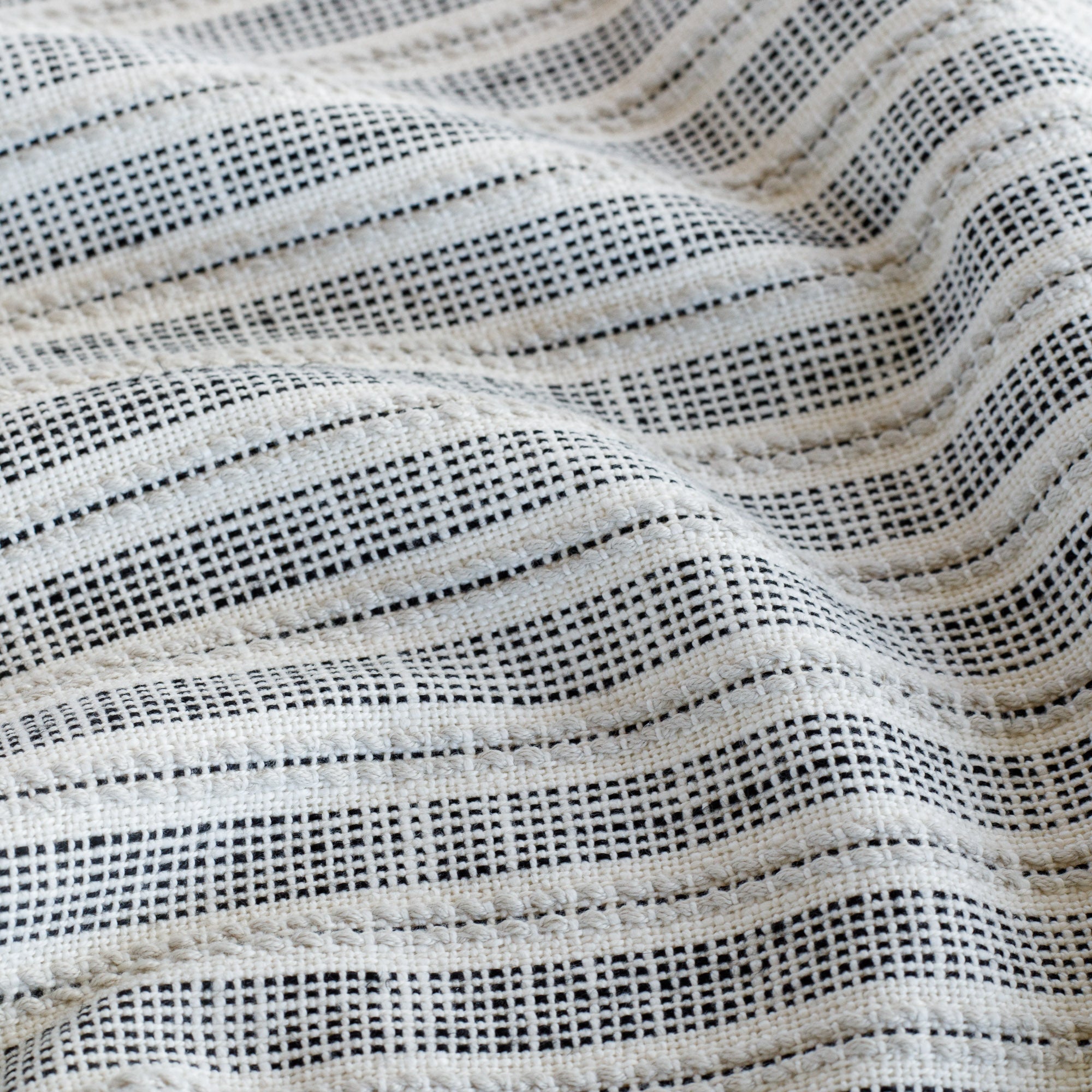 a white and black stripe outdoor upholstery fabric : close up view