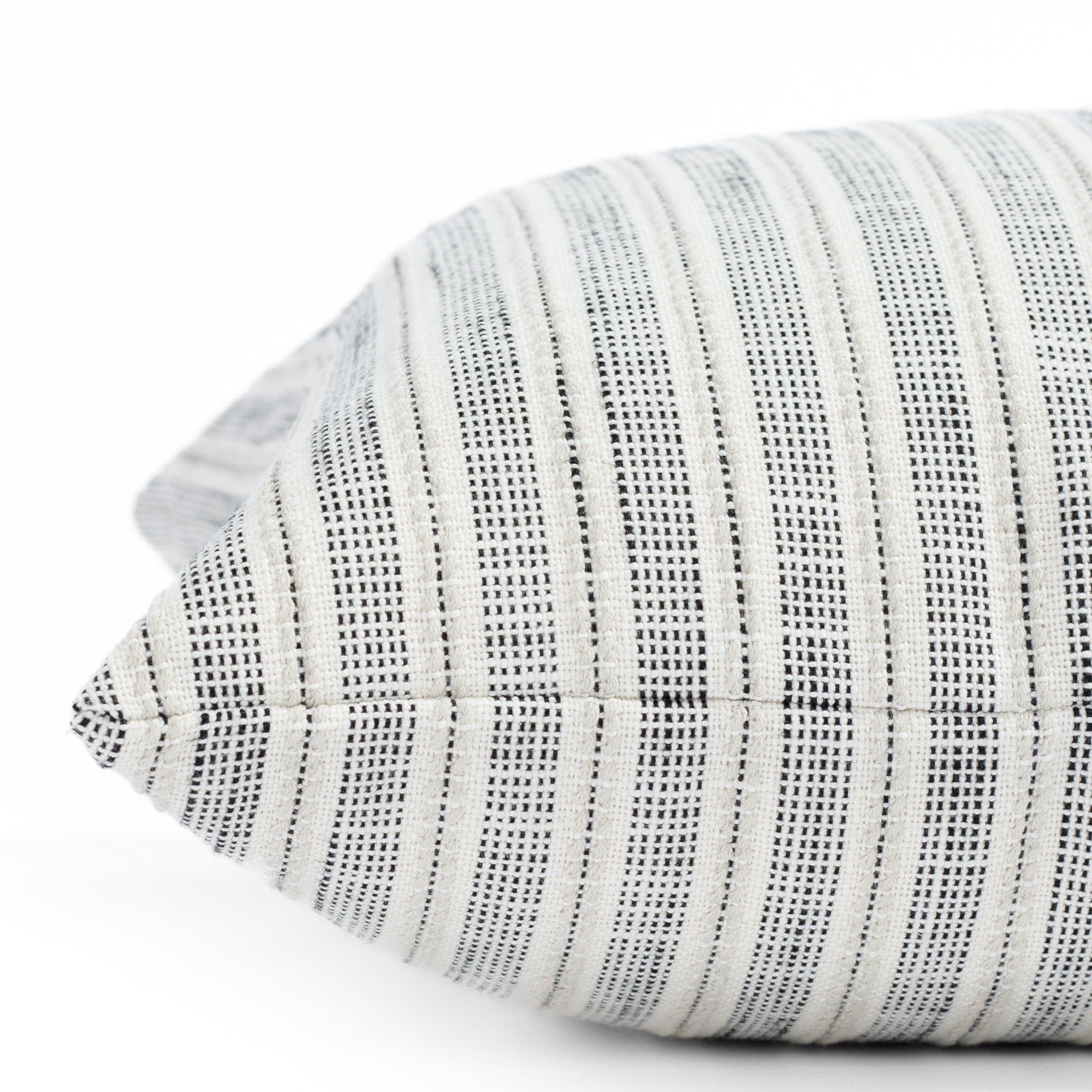 a cream and black stripe outdoor pillow : close up side view