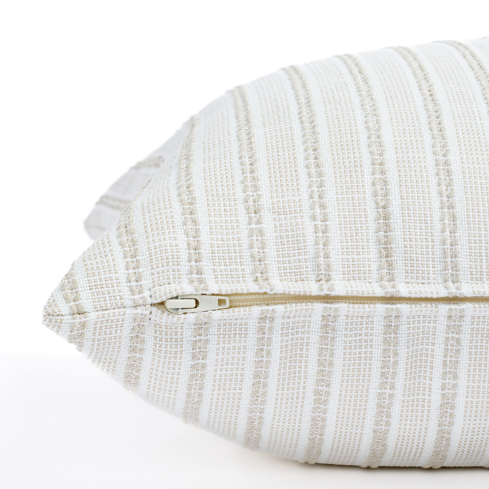 a white and sand stripe outdoor throw pillow : close up side zipper view