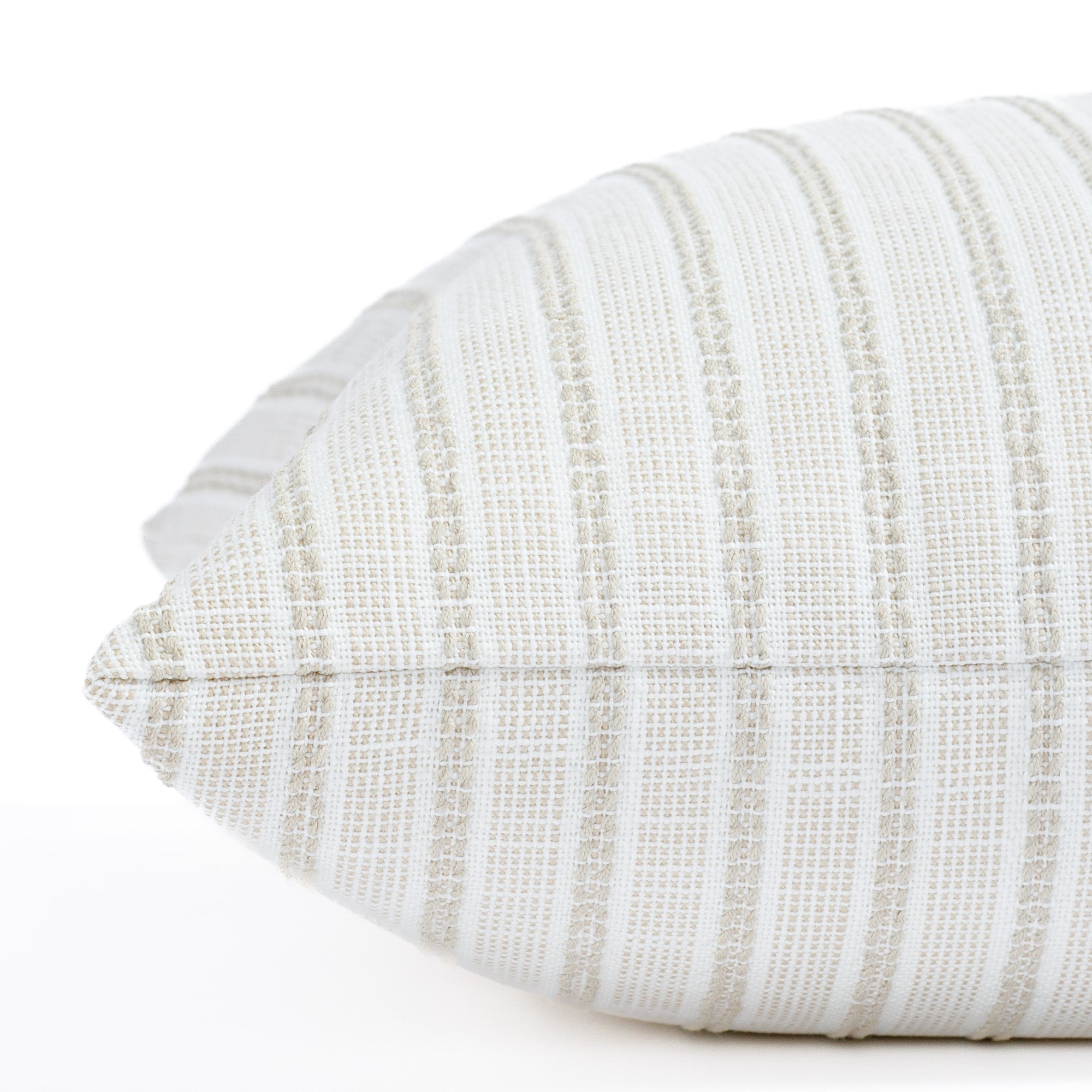 a white and sand stripe outdoor throw pillow : close up side view