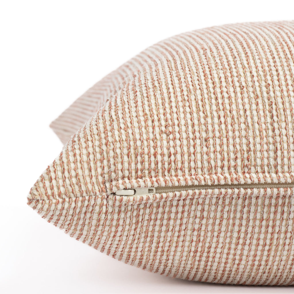 a terracotta pink and taupe textured outdoor pillow : close up zipper view
