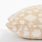 a soft gold and cream abstract floral patterned throw pillow : close up side view