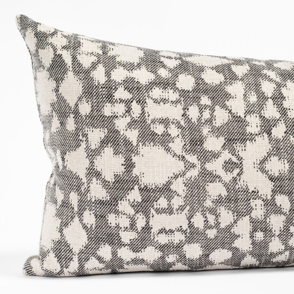 a black and cream abstract floral patterned lumbar throw pillow : close up view