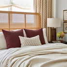 Bedford 22x22 burgundy pillows + Baker beige lumbar pillow styled on a bed