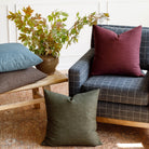 Tonic Living Bedford 22x22 pillows in Merlot, Moss, Coffee, and Denim styled together in a living room scene.