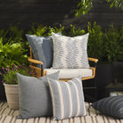 Tonic Living outdoor pillow collection styled on a patio in blue, white, and coastal-inspired tones.