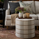 Cozy living room with Buckley Wheat round ottoman, Dunrobin Stripe Sable and Manor Tapestry Sage pillows – Tonic Living