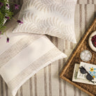 Overhead view of Tonic Living Swoon Sand decorative cushion with Caper Linen pillow on an outdoor rug.