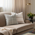 Two neutral patterned cushions from Tonic Living, styled on a brown velvet sofa.