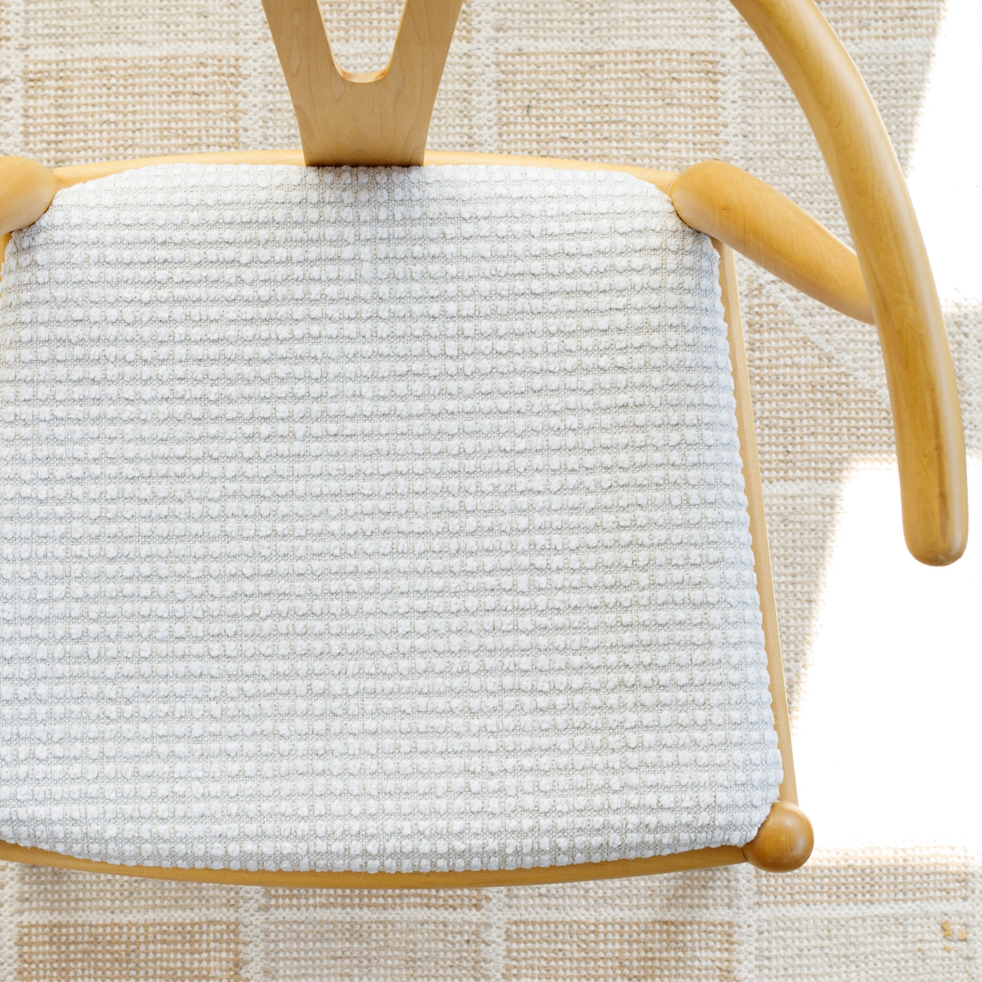 a creamy white textured grid patterned high performance upholstered chair seat