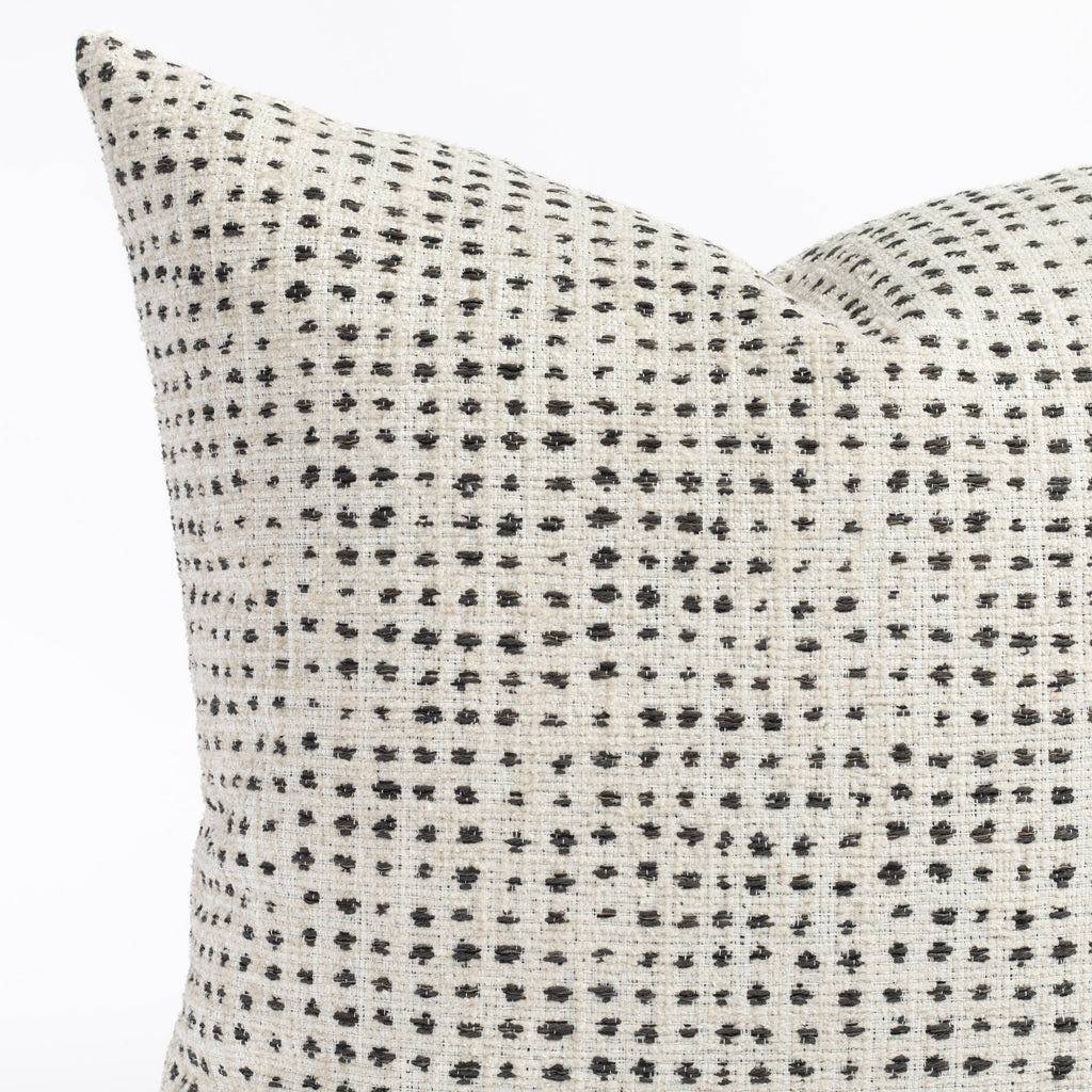 a cream and black polka dot throw pillow : close up view