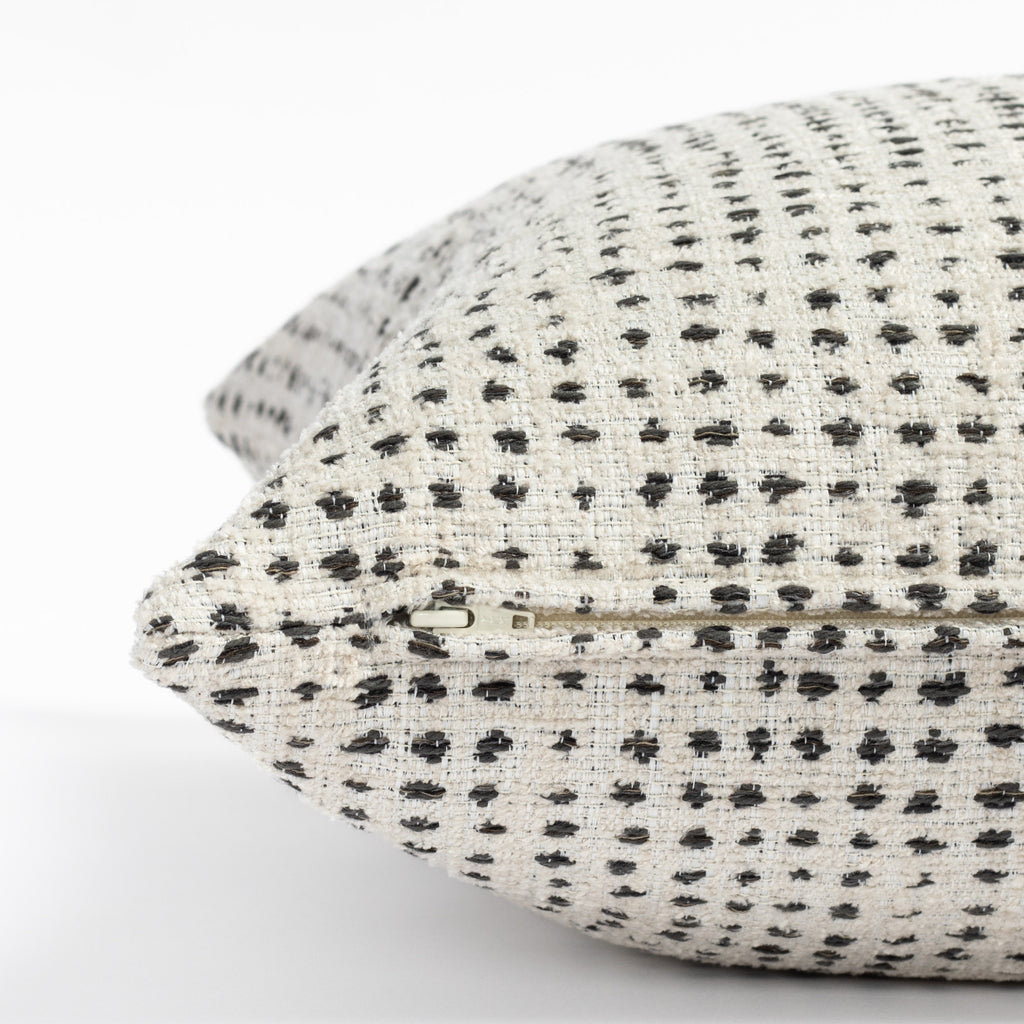 a cream and black polka dot throw pillow : close up zipper view