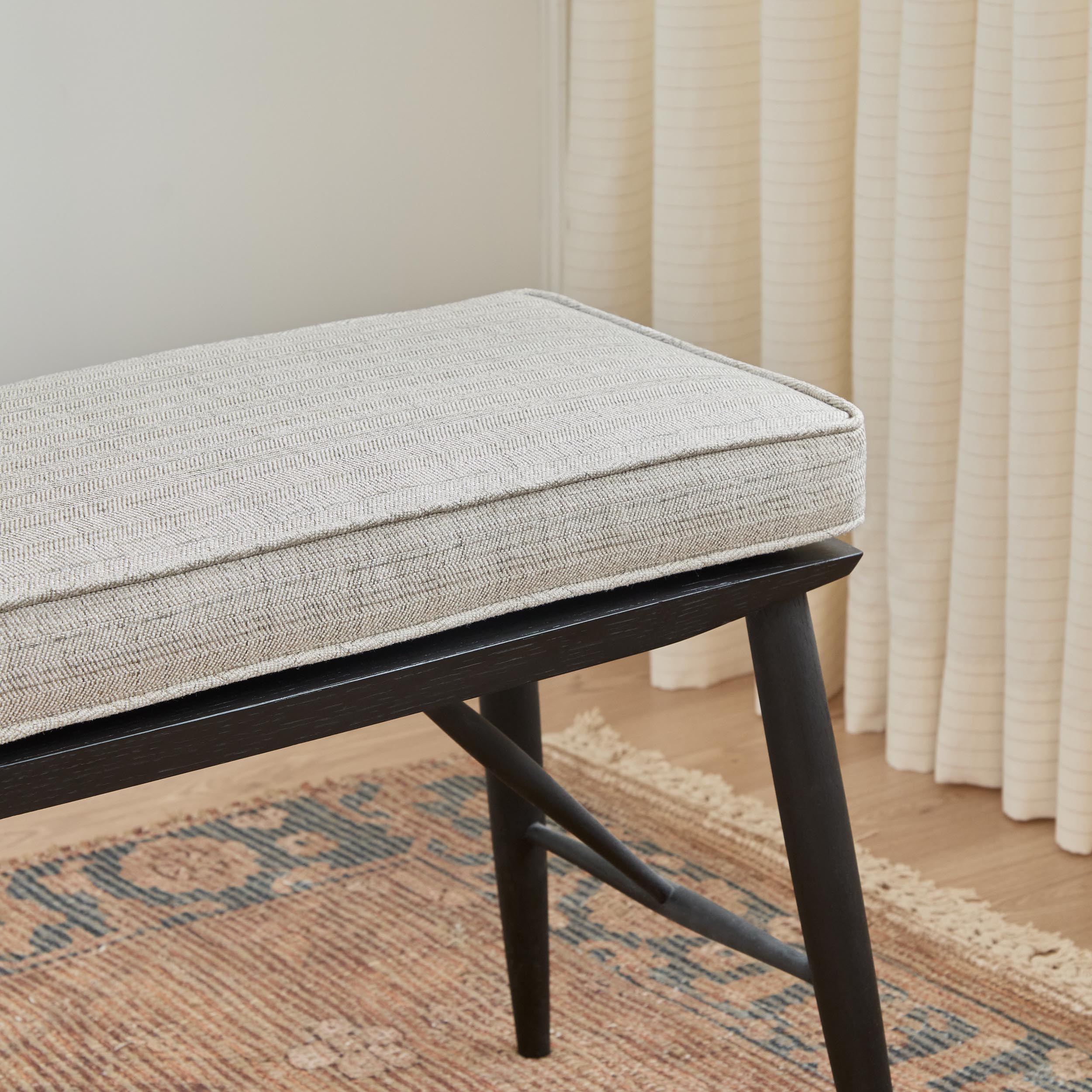 Chester Fabric, Pebble by Tonic Living — high-performance upholstery fabric in warm grey herringbone, shown on a bench seat cushion.