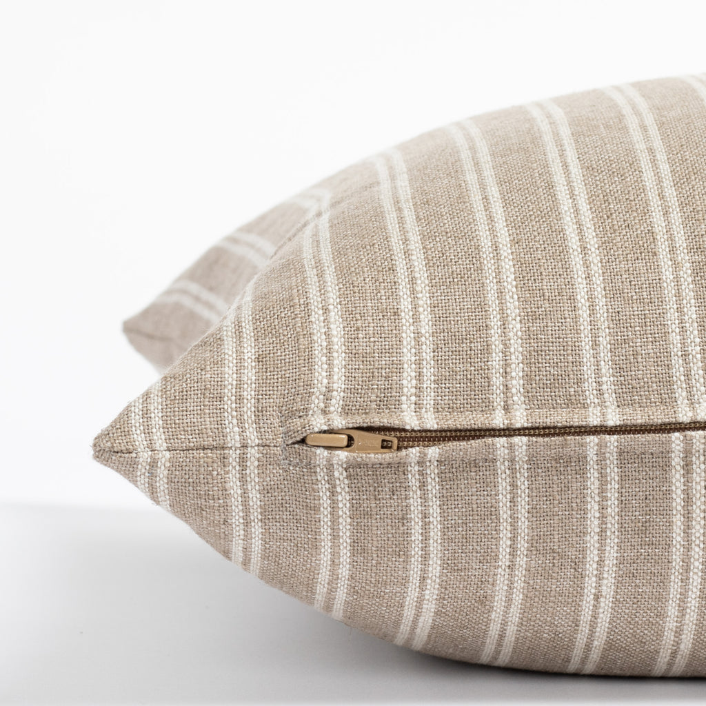 a light brown and oatmeal beige vertical stripe throw pillow : close up zipper view