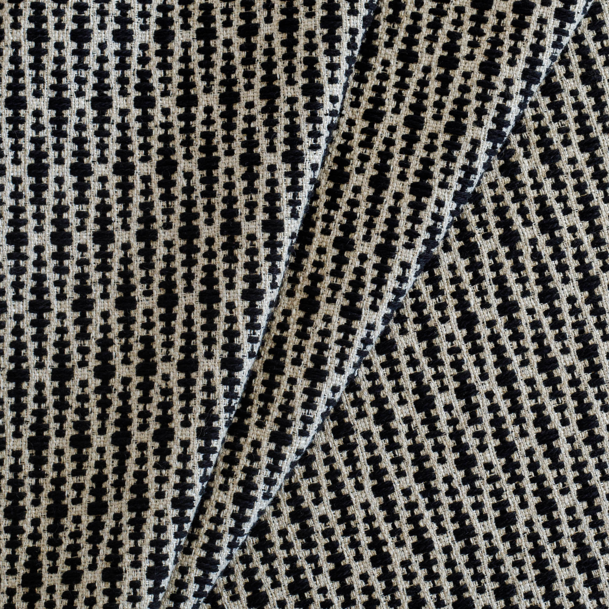 Dario Carbon, a black and tan textured geometric patterned home decor fabric from Tonic Living