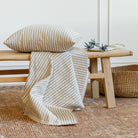 Dash 22x22 pillow in ochre styled with matching Dash upholstery fabric on a bench, Tonic Living.