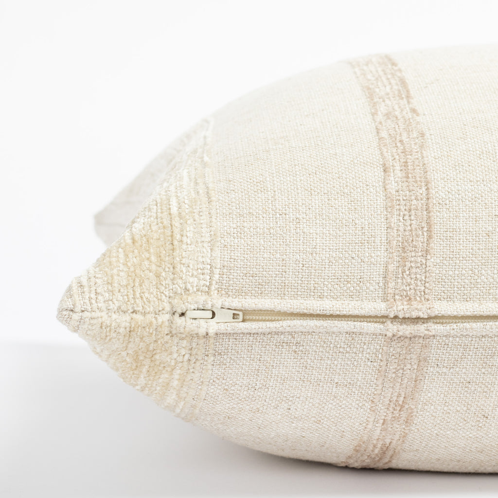 a neutral oatmeal beige tone on tone vertical chenille striped throw pillow: close up zipper detail