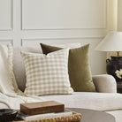 Tonic Living Emmett Plaid beige throw pillow styled on a sofa with the Florence Velvet 22x22 Pillow in Olive green.