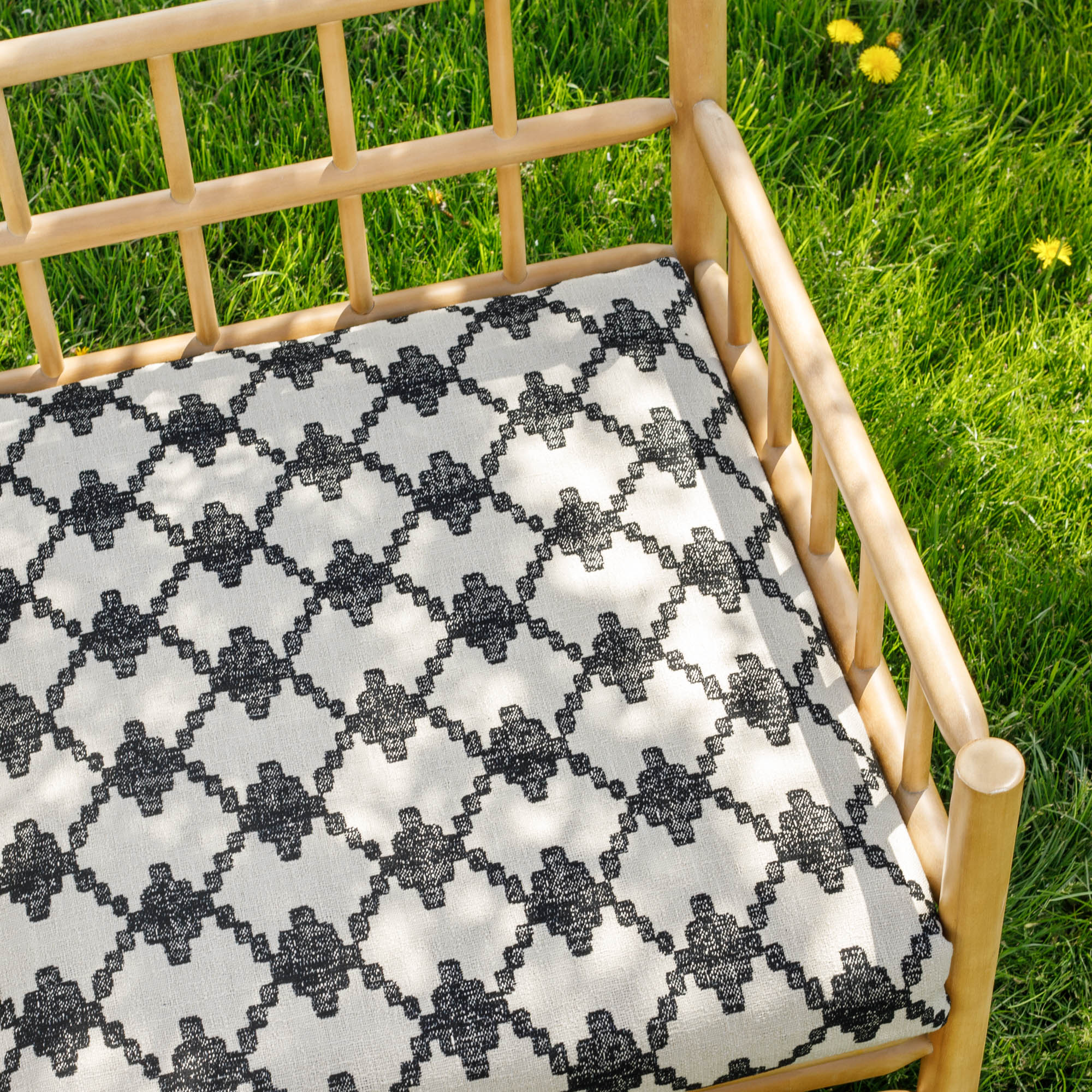 a black and beige abstract geometric patterned outdoor upholstery fabric bench cushion