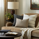 Tonic Living Crosby Stripe Truffle decorative lumbar pillow styled with striped and checked cushions in a neutral living room.