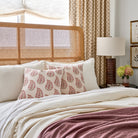 Tonic Living Grace 20x20 Pillow, Rosewood styled on a bed, featuring pink & red floral paisley pattern.