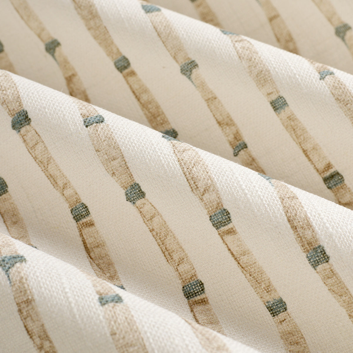 Close up of Tonic Living Hadley Stripe drapery fabric showing its detailed bamboo-inspired stripes in blue and light brown on off-white.