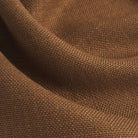 Close up of Tonic Living Hampton Cinnamon upholstery fabric showing its warm cinnamon brown colour, russet tones, and linen-like woven texture.
