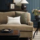 Tonic Living Hampton Moss decorative pillow styled on a sofa with a neutral Gibson Stripe lumbar cushion in a moody living room.