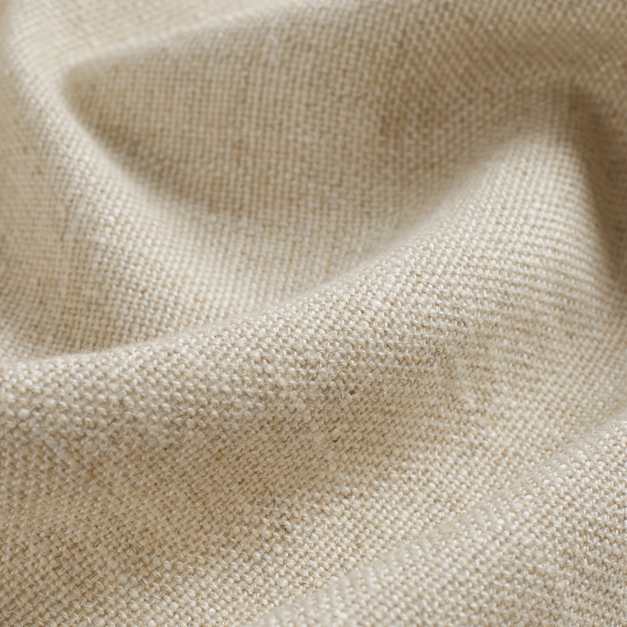 Close up of Tonic Living Hampton Oatmeal fabric showing textured beige weave with a linen-inspired finish.