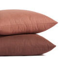 Stack of Tonic Living Hampton pillows in Rosewood earthy pink and Burgundy deep red-brown with linen-inspired texture.