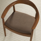 Tonic Living Hampton Walnut high-performance upholstery fabric shown on a dining chair seat in a smoky walnut brown.