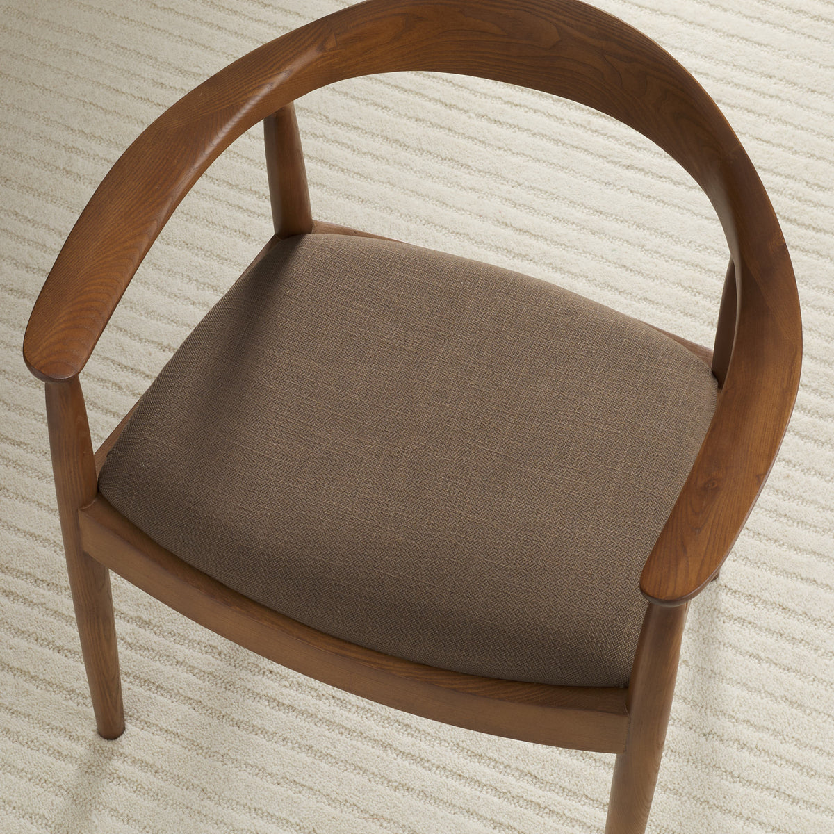 Tonic Living Hampton Walnut high-performance upholstery fabric shown on a dining chair seat in a smoky walnut brown.