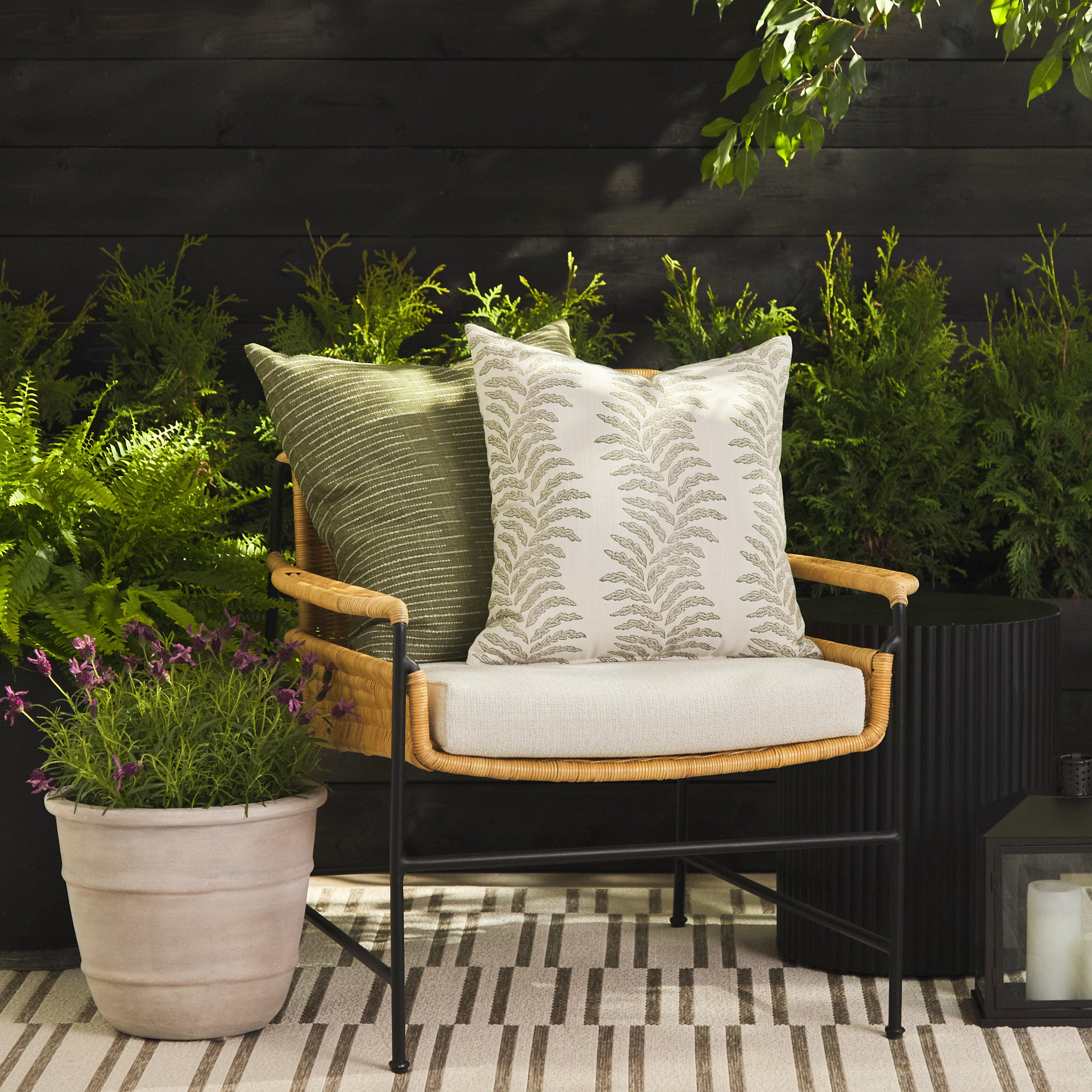 Tonic Living Swoon Sage outdoor cushion styled on a chair with Hawthorne Basil 22x22 pillow in a green outdoor setting.