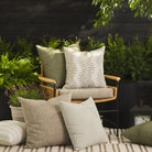 Tonic Living outdoor pillow collection styled on a patio in green, white, and neutral tones.
