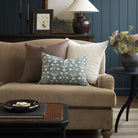 Tonic Living Hampton Walnut decorative cushion styled on a sofa with a mix of blue and brown Tonic Living pillows in a moody living room.