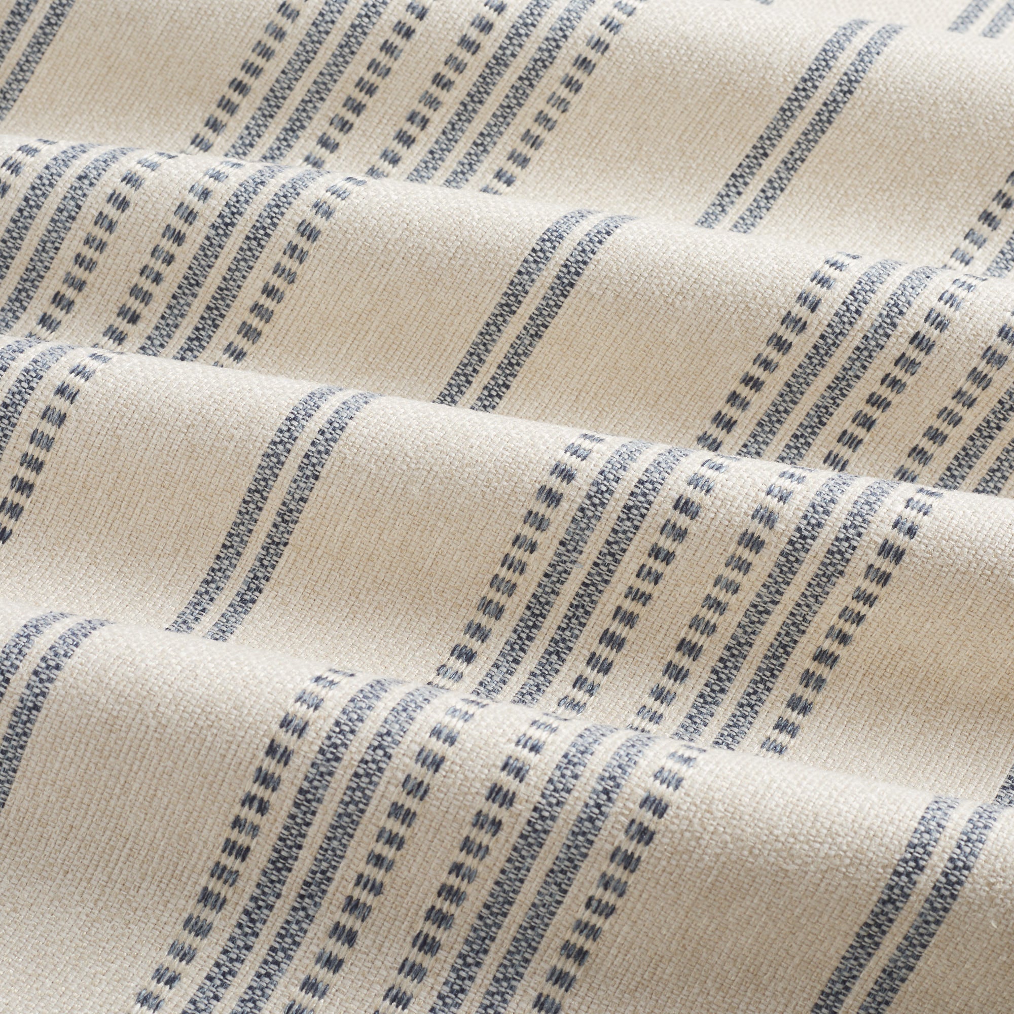 Tonic Living Hopper Stripe Denim high-performance fabric with rippled movement showing blue stripes on tan base.
