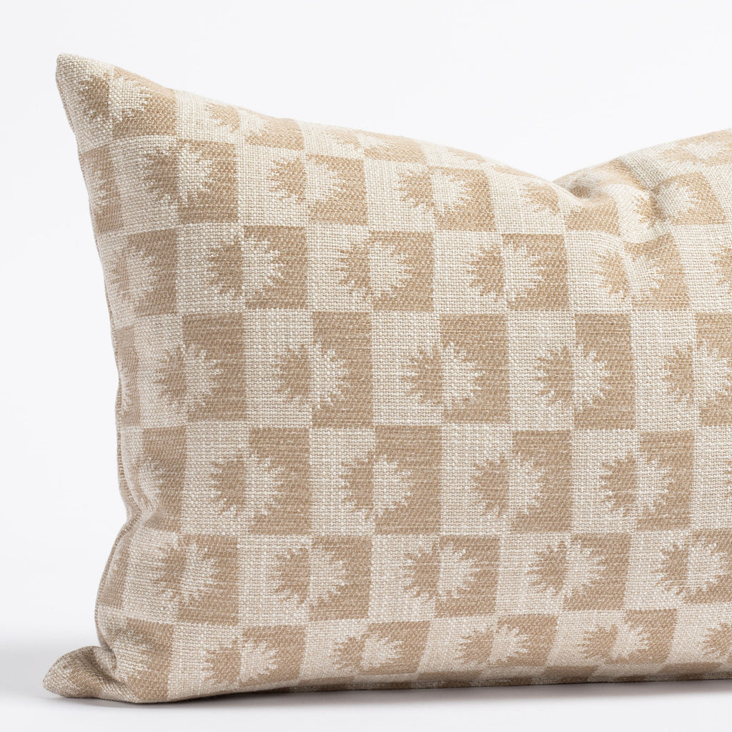 a beige and light brown sun motif checker patterned lumbar throw pillow : close up view