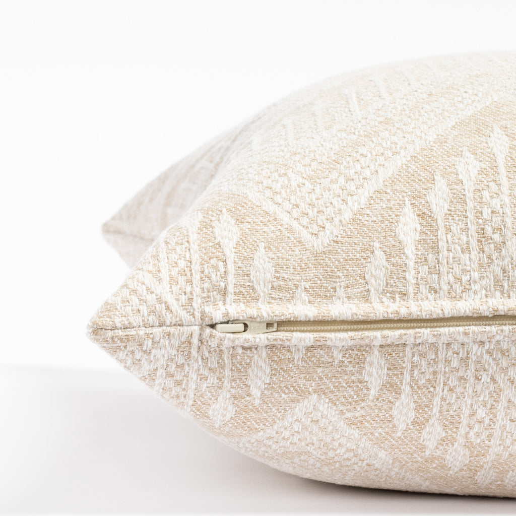 an oatmeal beige and white intricate zigzag patterned throw pillow : close up zipper view