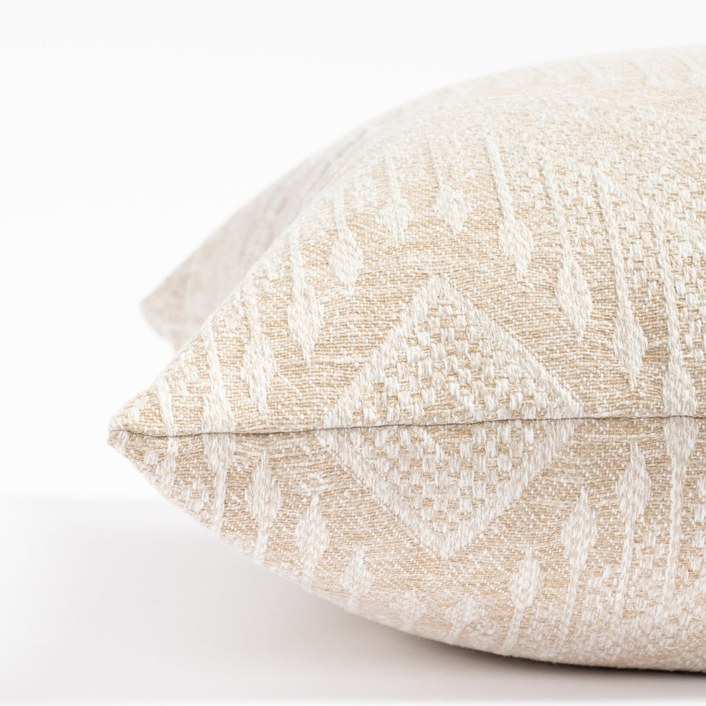 an oatmeal beige and white intricate zigzag patterned throw pillow : close up side view