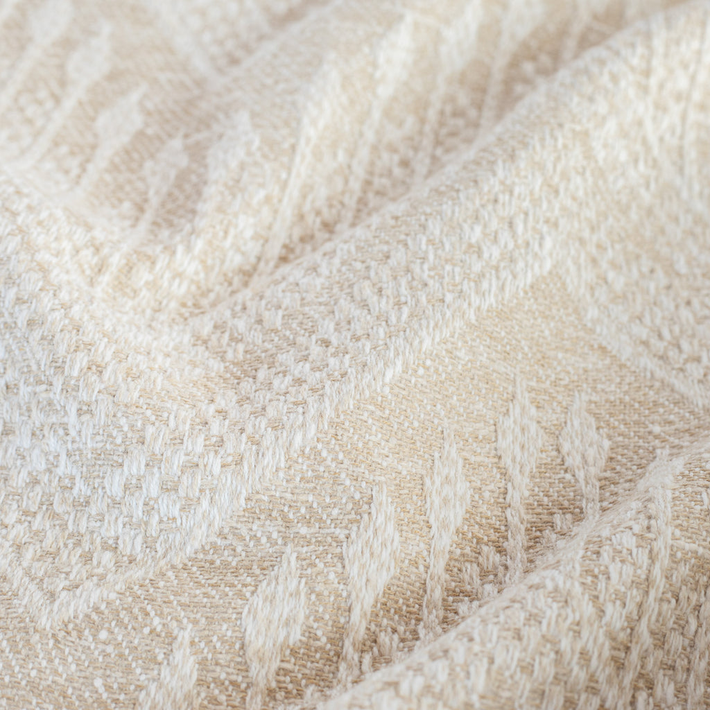 a beige upholstery fabric with a delicate woven white geometric pattern : close up view