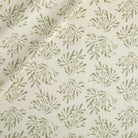 Tonic Living Juniper Fabric in Sage, a faded sage green and cream botanical print drapery fabric with sprig pattern.