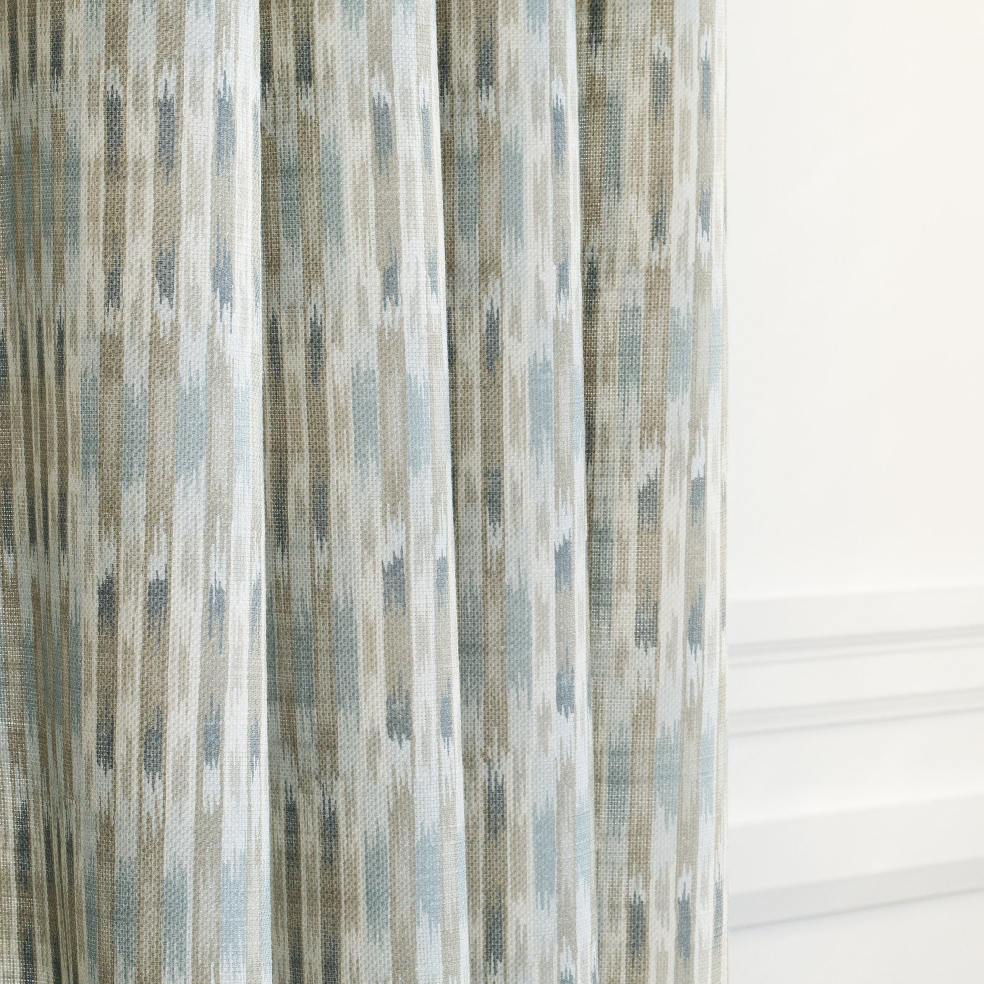 a blue and sand ikat print curtain fabric