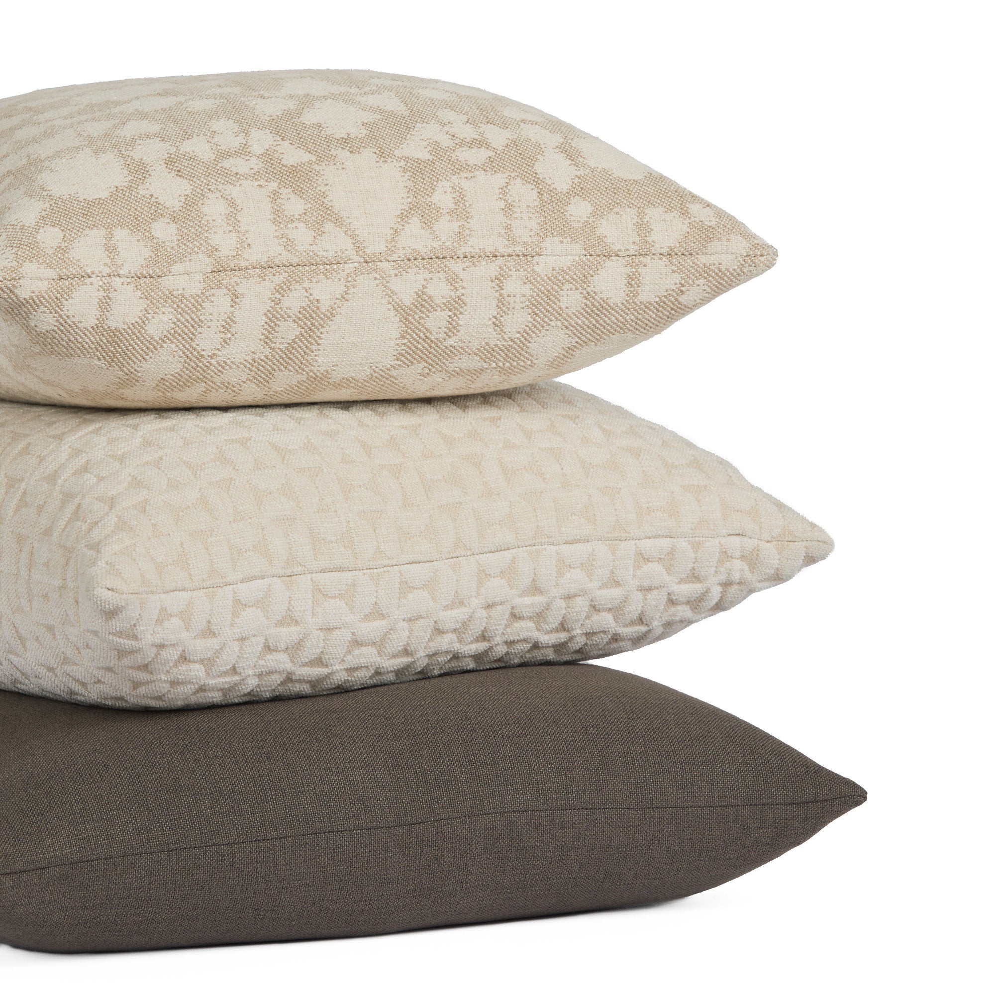 Stack of pillows featuring Loden 22x22 Pillow, Mink with Astrid 20x20 Pillow, Natural and Bella 22x22 Pillow, Pearl by Tonic Living — soft, layered neutrals with subtle texture.