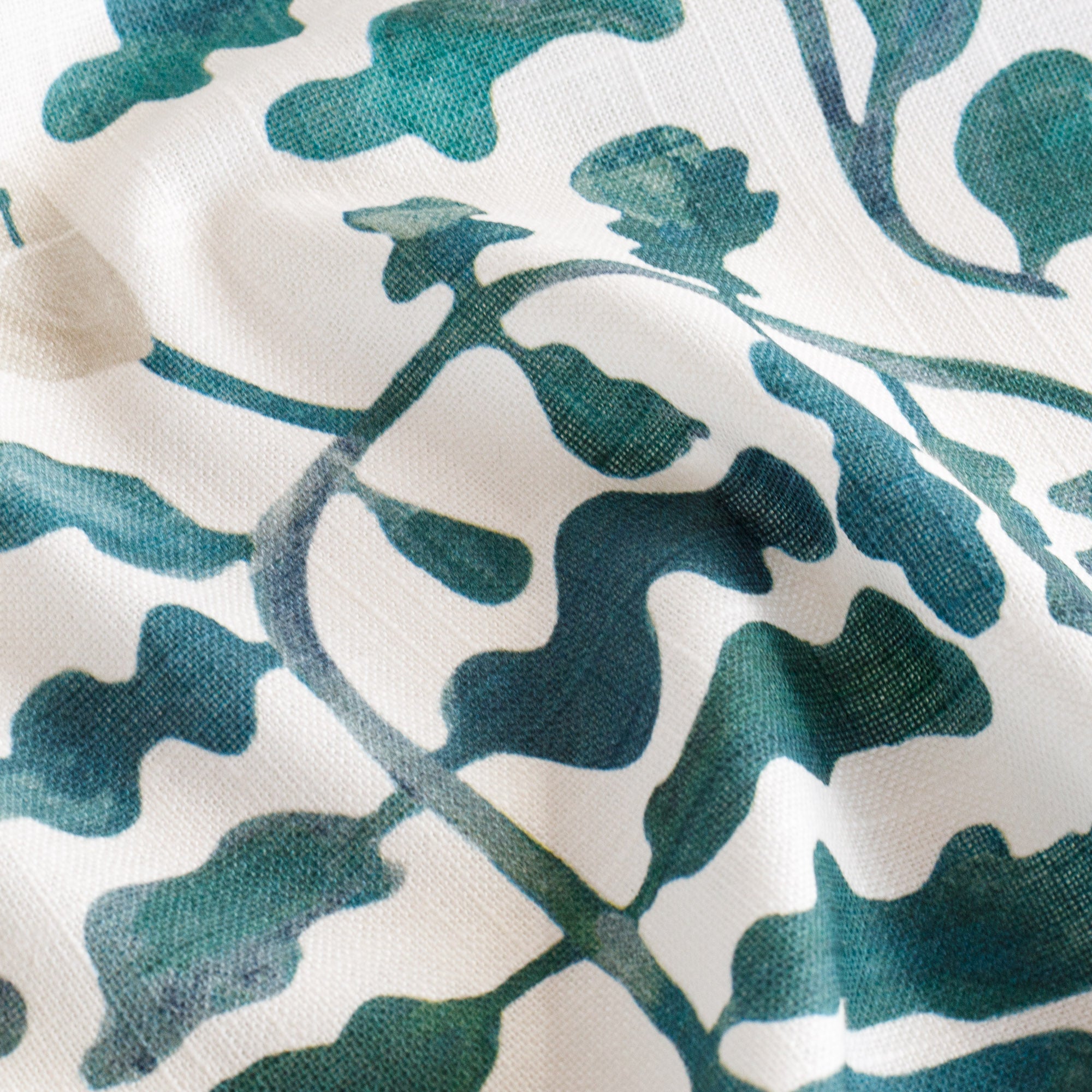 a teal and forest green and white leafy botanical print fabric : close up view